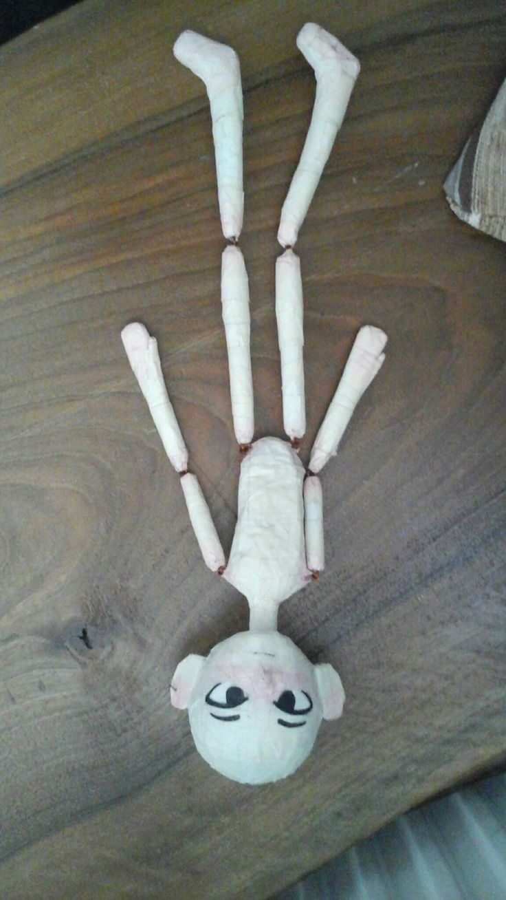 a stuffed animal that is on top of a wooden table with bones attached to it