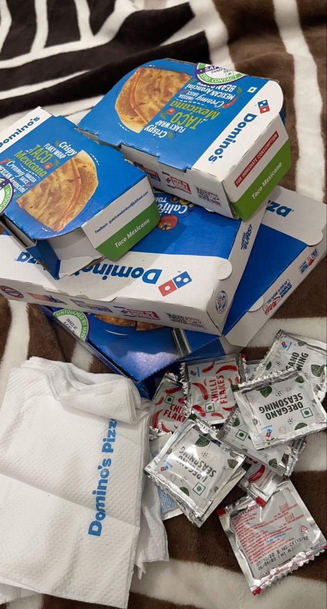 several packages of diapers are stacked on top of each other in front of a zebra print blanket