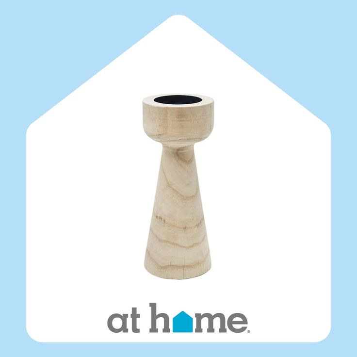 a wooden candle holder sitting on top of a blue and white background with the words at home written below it