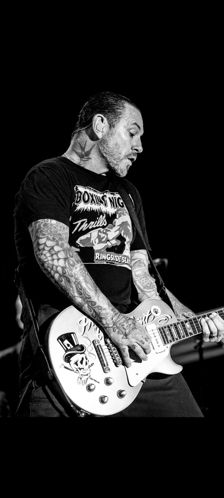 a man with tattoos playing an electric guitar