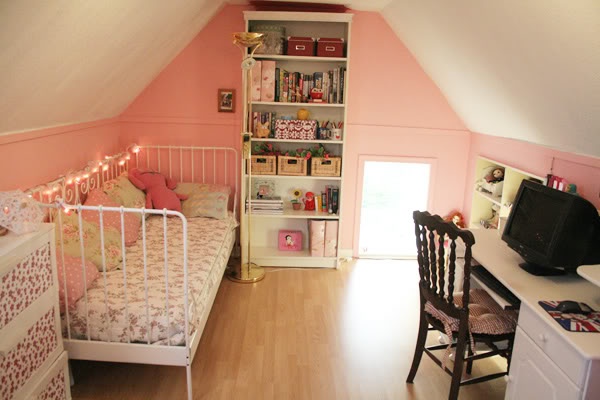 an attic bedroom with pink walls and white furniture