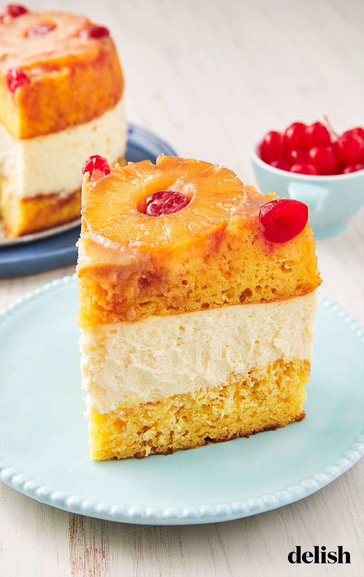 two pieces of pineapple upside down cake on a plate with cherries in the background