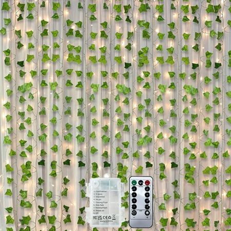 a remote control sitting on top of a table next to a wall covered in vines