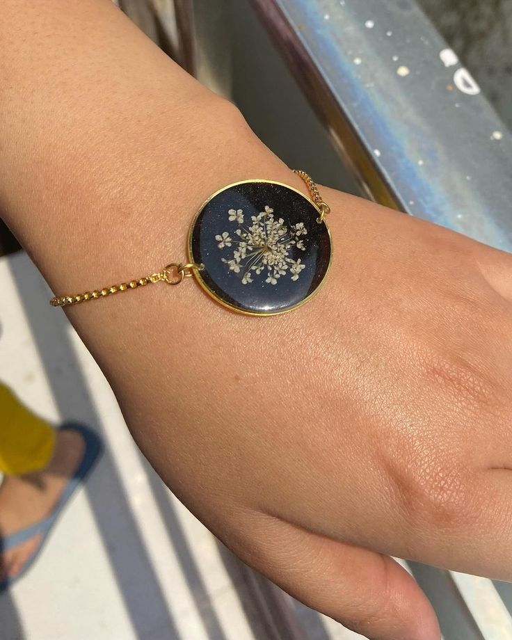 a woman's hand wearing a bracelet with a snowflake on it