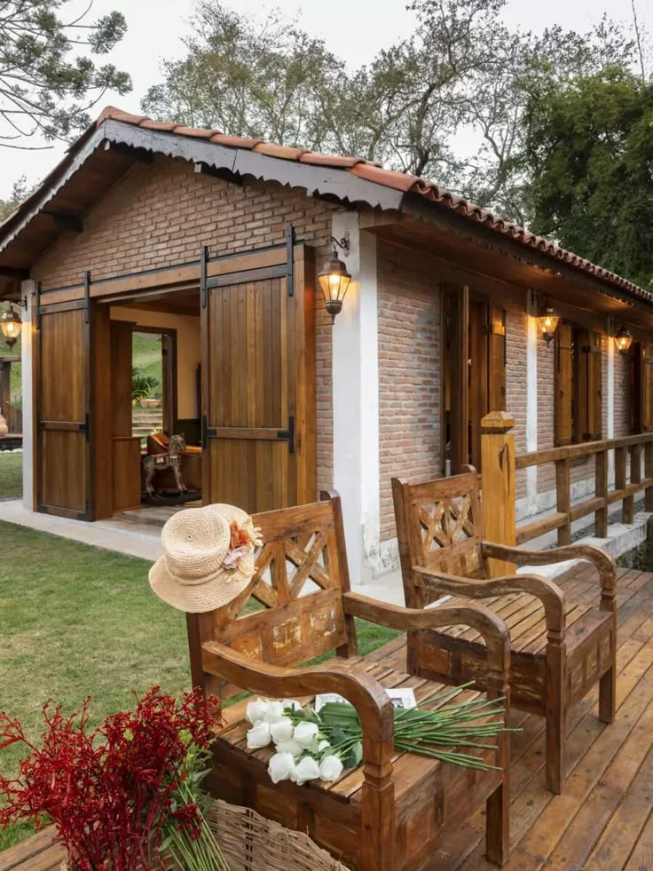 a wooden bench sitting on top of a wooden deck next to a small brick building