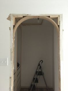 a ladder leaning against the wall in an unfinished room with white walls and wood floors