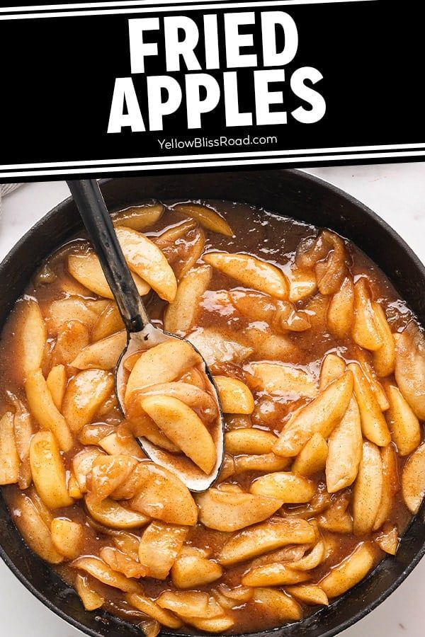 a frying pan filled with fried apples on top of a counter next to a sign that says fried apples