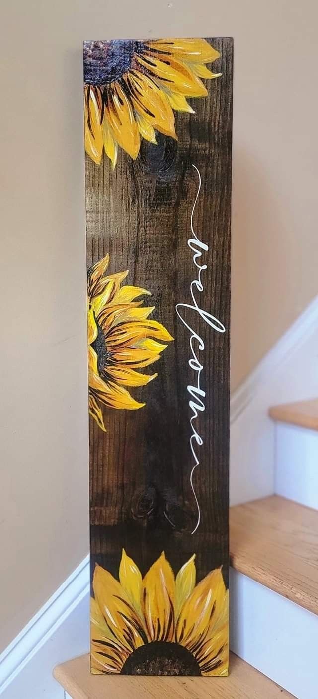 a wooden sign with sunflowers painted on it