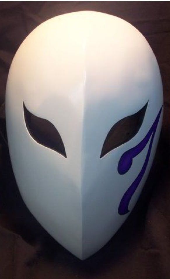 a white mask with purple designs on it