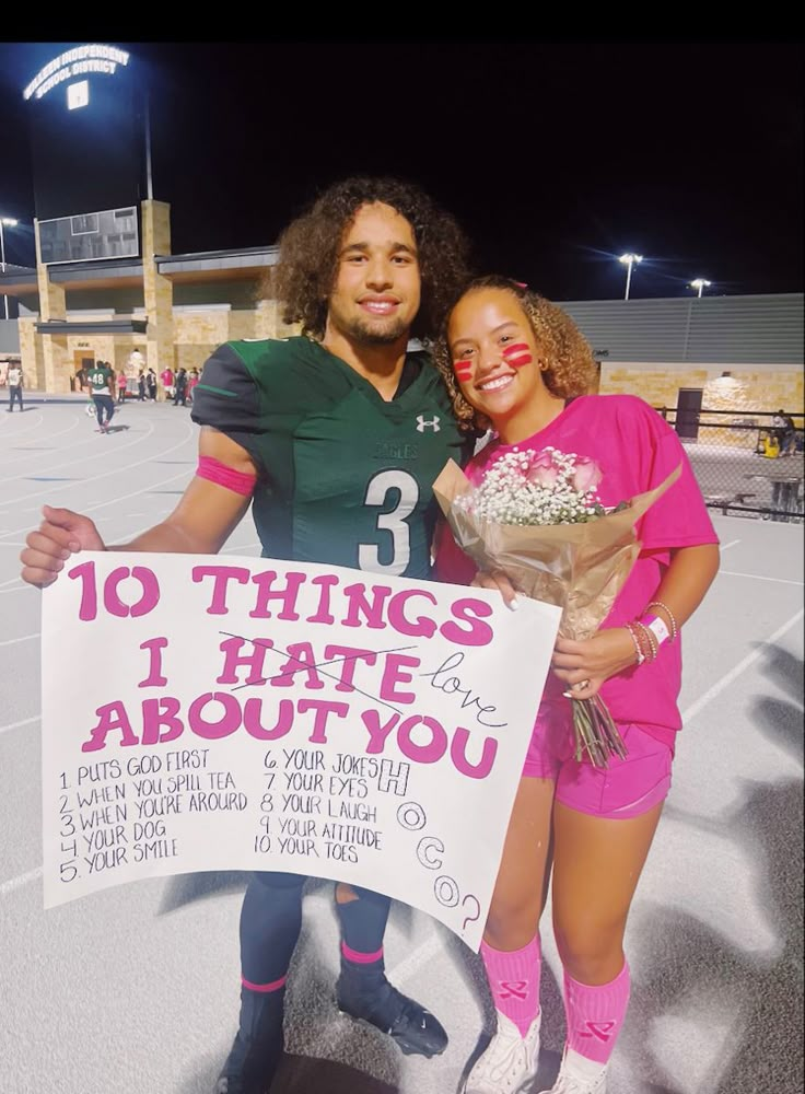 a man and woman standing next to each other holding a sign that says 10 things i hate about you