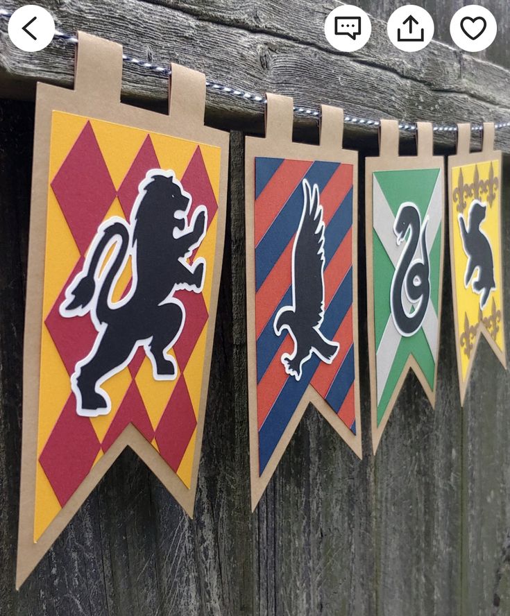 some flags are hanging on the side of a wooden fence with one flag in the shape of a lion and two lions