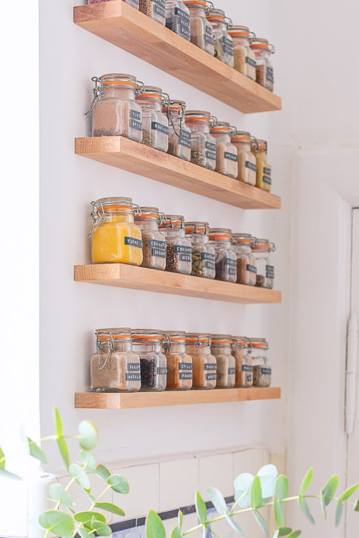 the shelves are filled with spices and jars on them, along with plants in pots