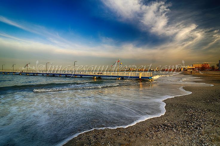 there is a boat that is sitting in the water on the beach near the pier