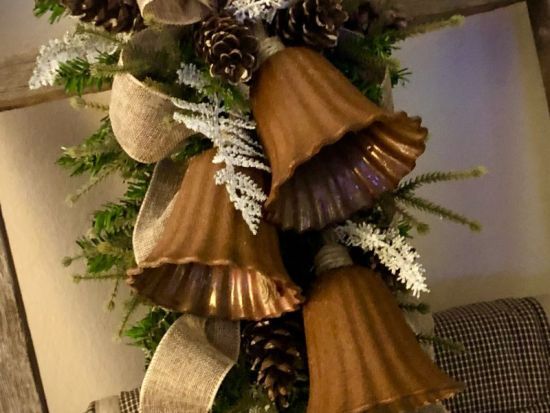 a christmas wreath with bells and pine cones