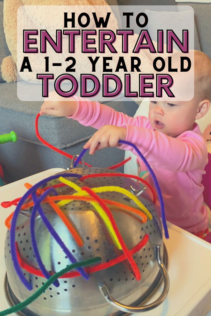 a toddler playing with an infant's toy on top of a potty