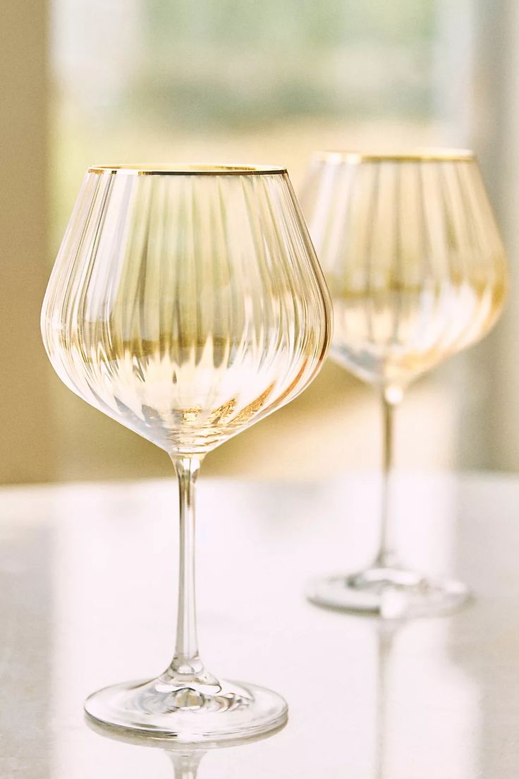 two wine glasses sitting on top of a table