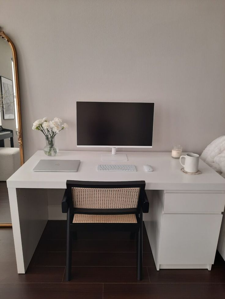 a white desk with a computer monitor and keyboard