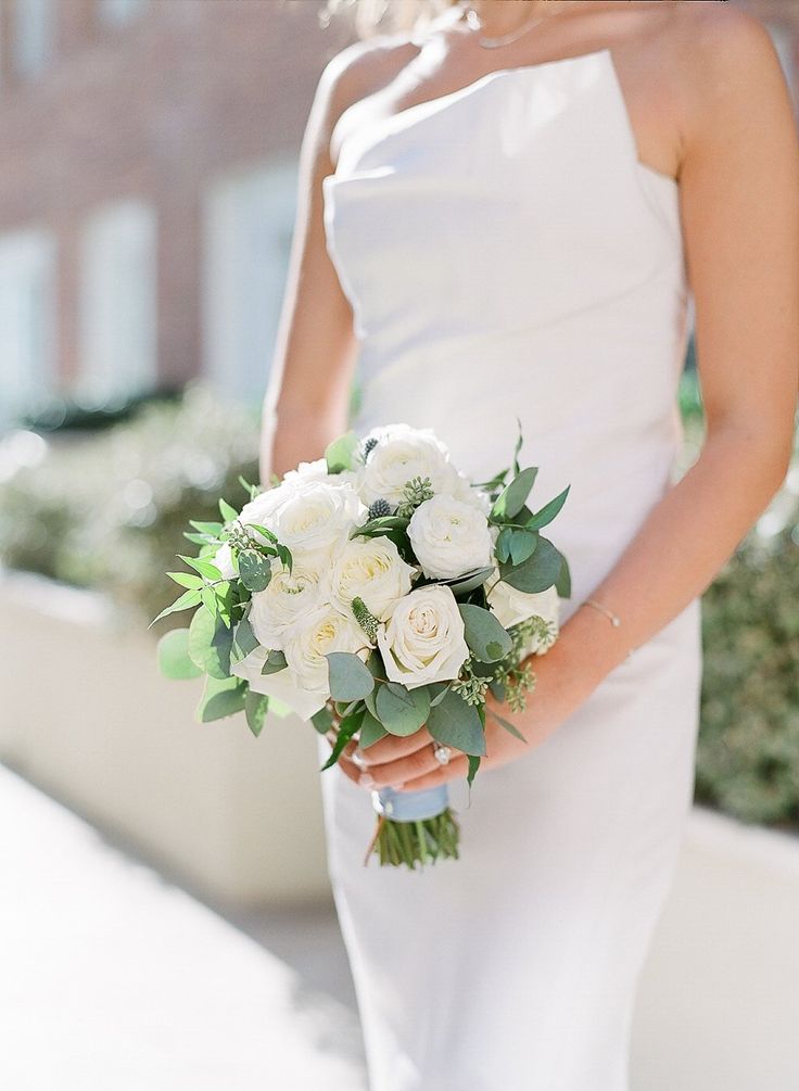 a woman in a white dress holding a bouquet