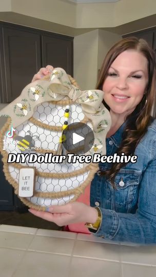 a woman holding up a decorative object in her hands with the words diy dollar tree beehive on it