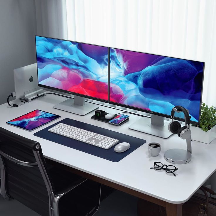 two computer monitors sitting on top of a white desk next to a keyboard and mouse