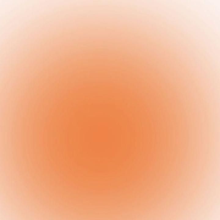 an orange and white background that is very blurry with the light at the top