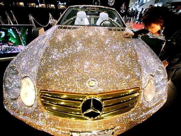 a woman standing next to a car covered in glitter