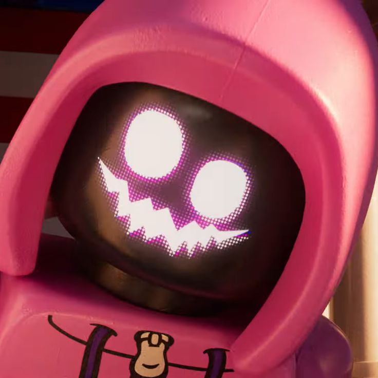 a pink toy with glowing eyes and a creepy face on it's head, sitting in front of an american flag