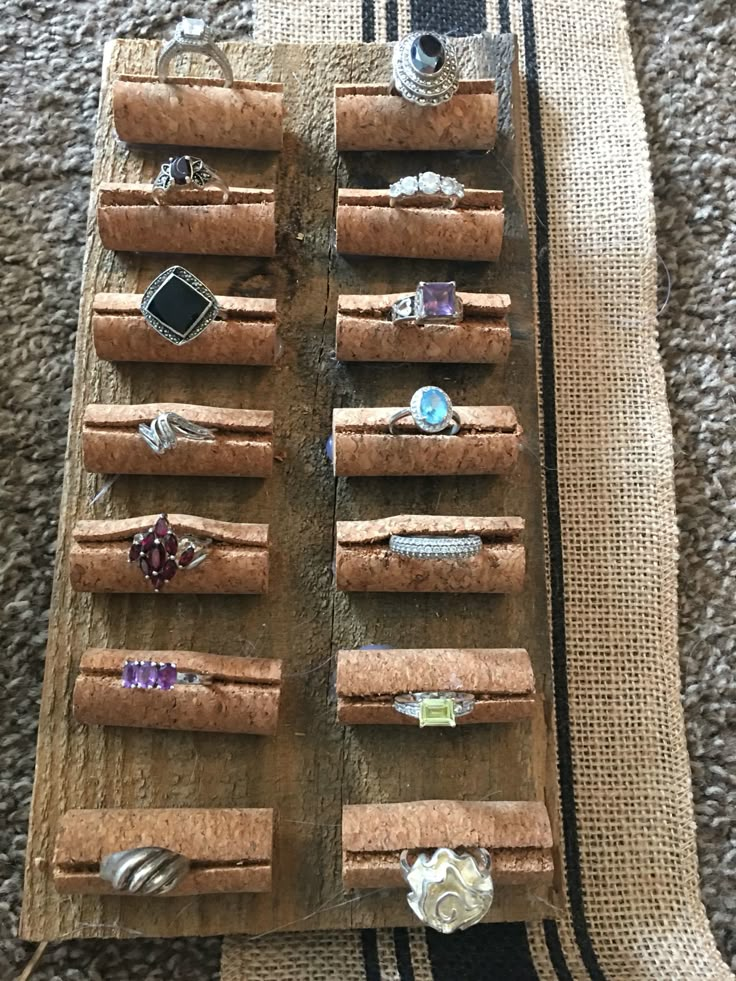 an assortment of rings are displayed on a piece of wood