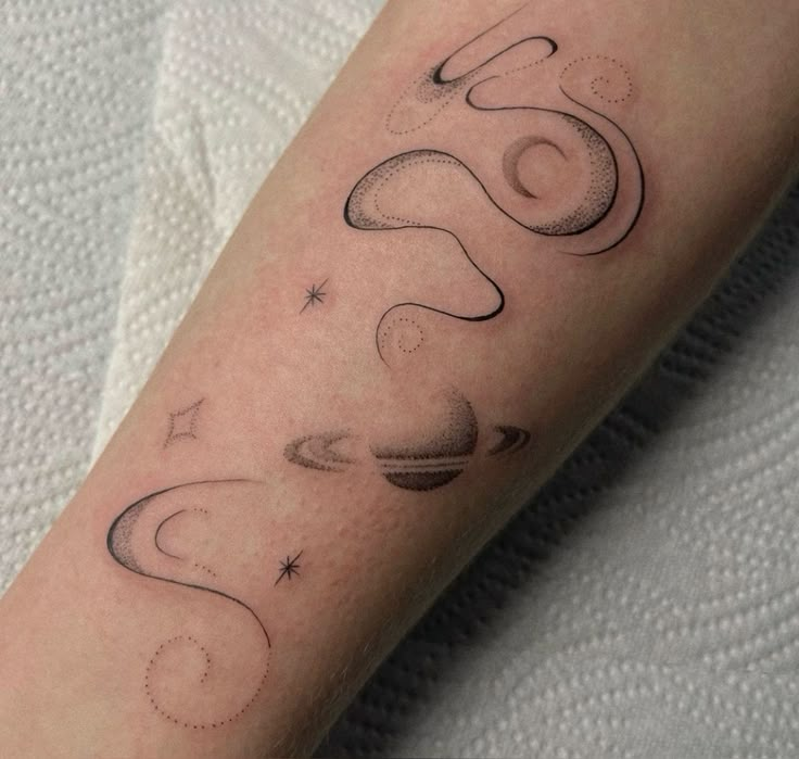 a person with a tattoo on their arm that reads 60 and has saturn in the background