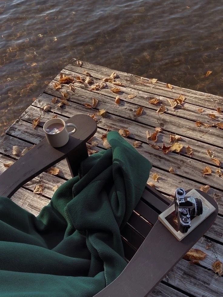 a cell phone sitting on top of a wooden table next to water