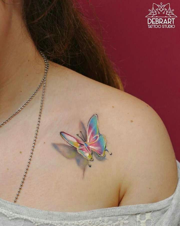 a woman with a butterfly tattoo on her shoulder and chest, showing it's colorful wings