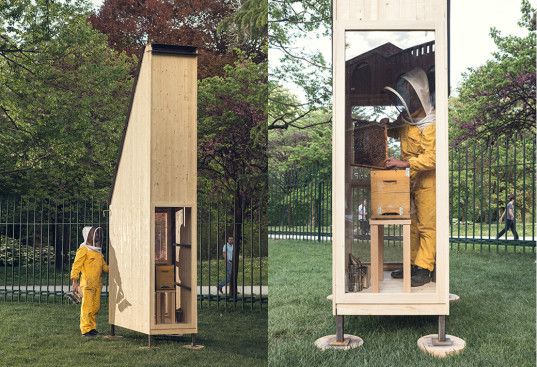 two people in yellow suits are standing near a tall wooden structure with a door open