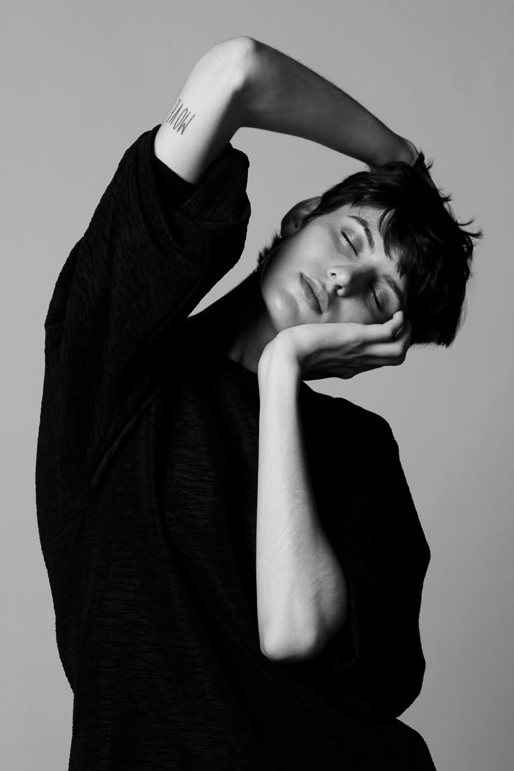 a black and white photo of a woman posing with her hands on her head,