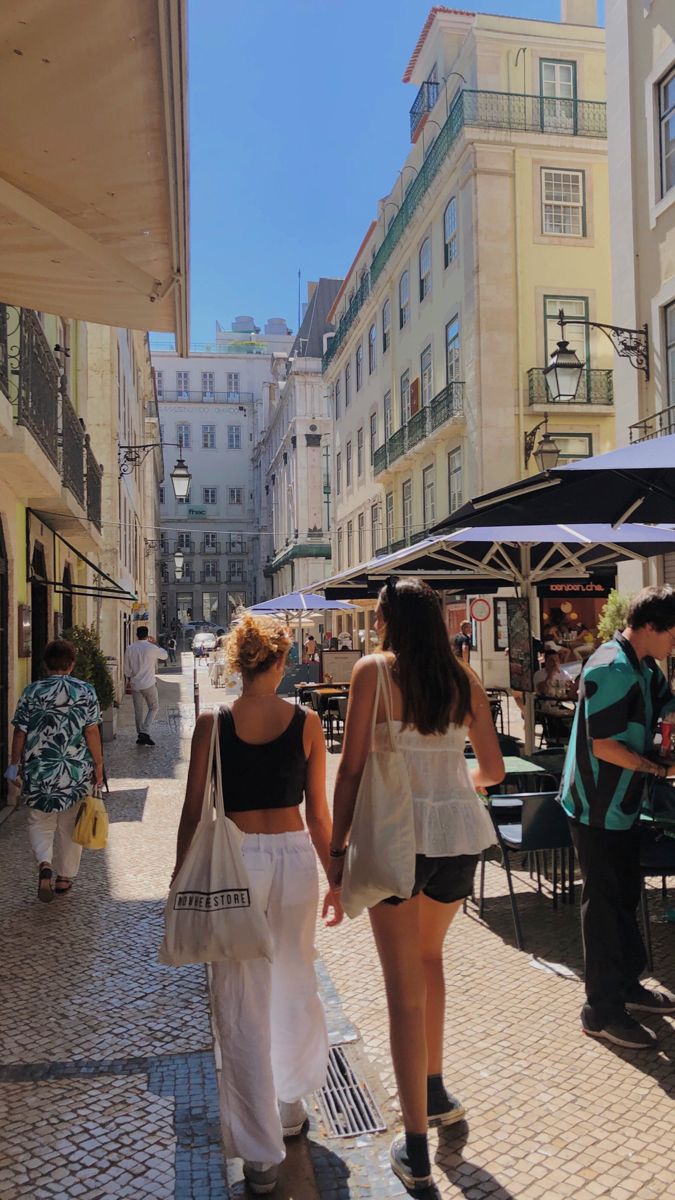 two women walking down the street holding hands