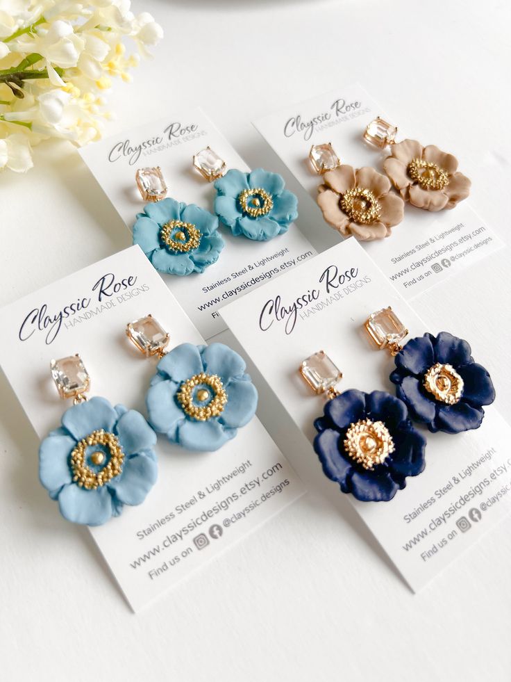 four pairs of flower clip earrings sitting on top of each other