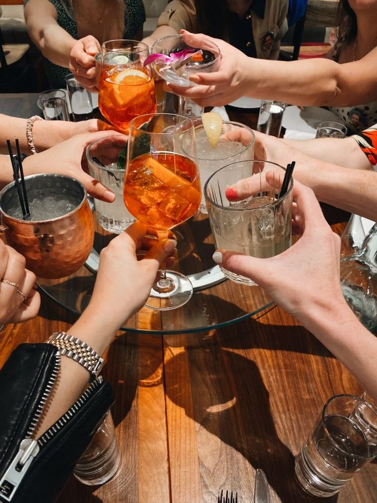 a group of people sitting around a table with drinks