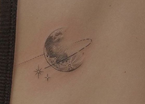 a woman's stomach with a small tattoo on the side of her belly and an airplane flying in front of it