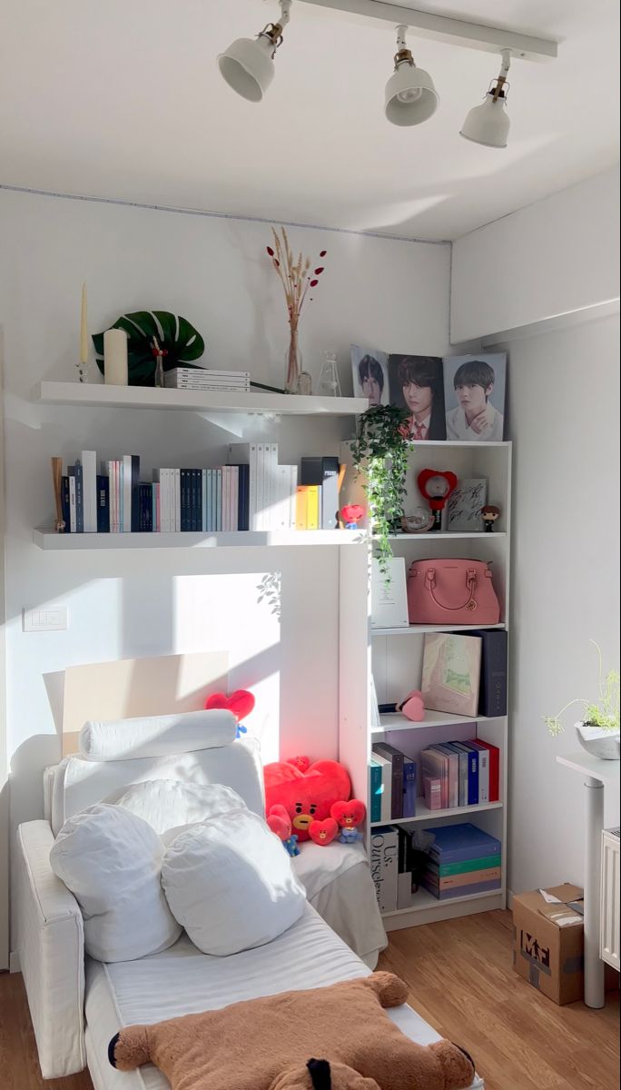 a white bed sitting in a bedroom next to a shelf filled with lots of books