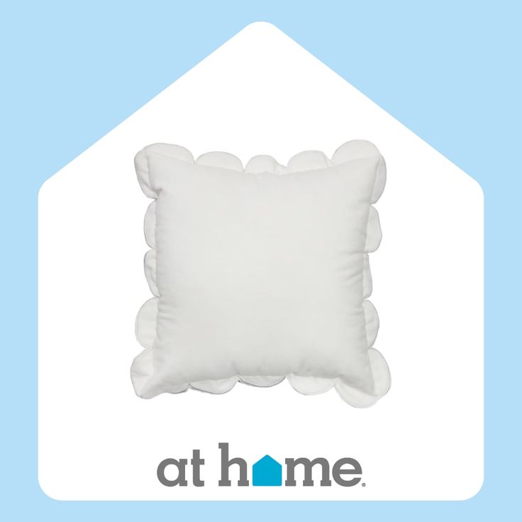 a white pillow sitting on top of a blue and white house shaped pillow with the words at home written below it