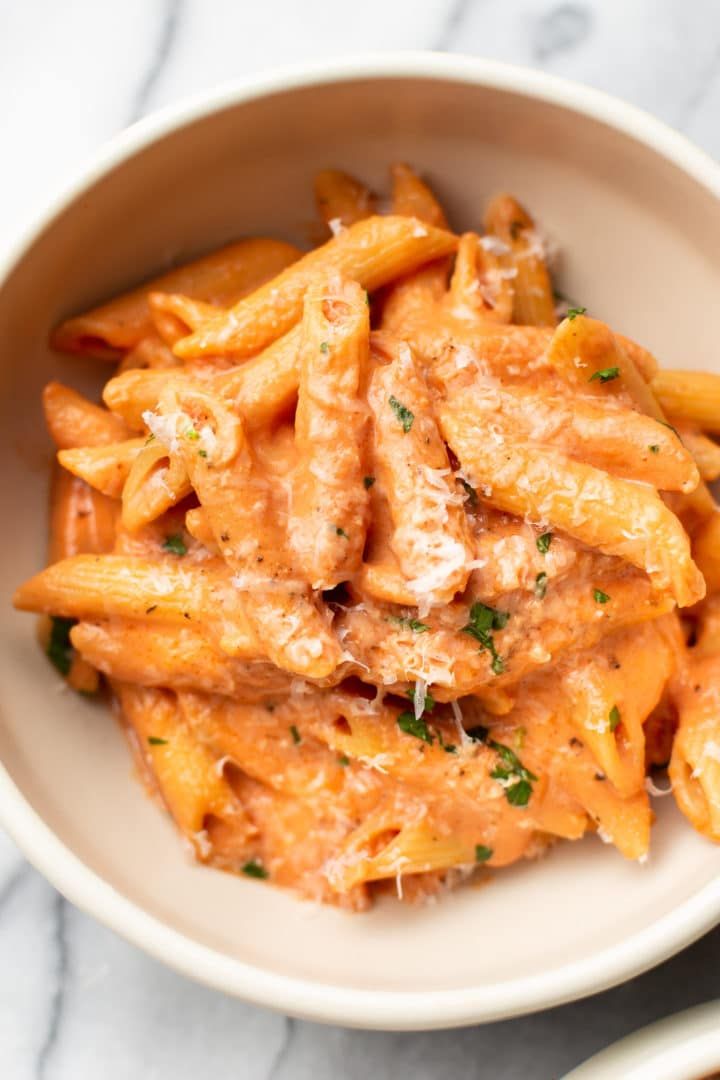 a white bowl filled with pasta covered in sauce