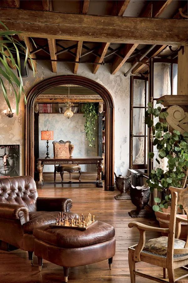 a living room filled with furniture and a large mirror on the wall above it's doorway