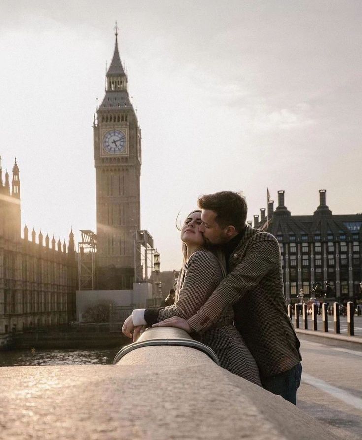 a man and woman standing next to each other in front of the big ben clock tower