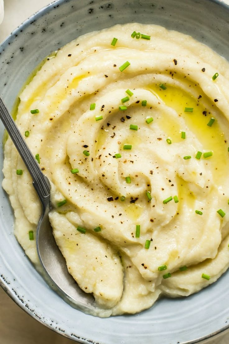 a bowl filled with mashed potatoes topped with chives