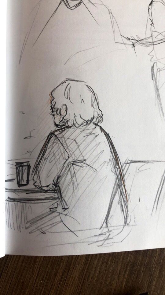 a drawing of a person sitting at a table with a cup in front of them