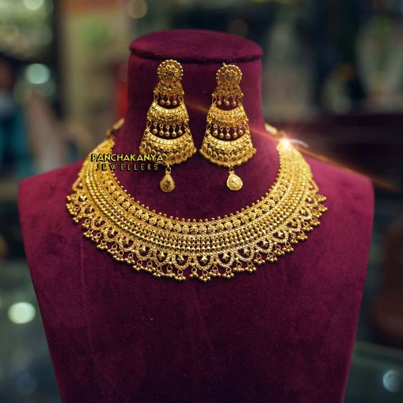 a gold necklace and earrings on display in a store