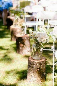 there are many chairs and vases with flowers in them on the grass near each other