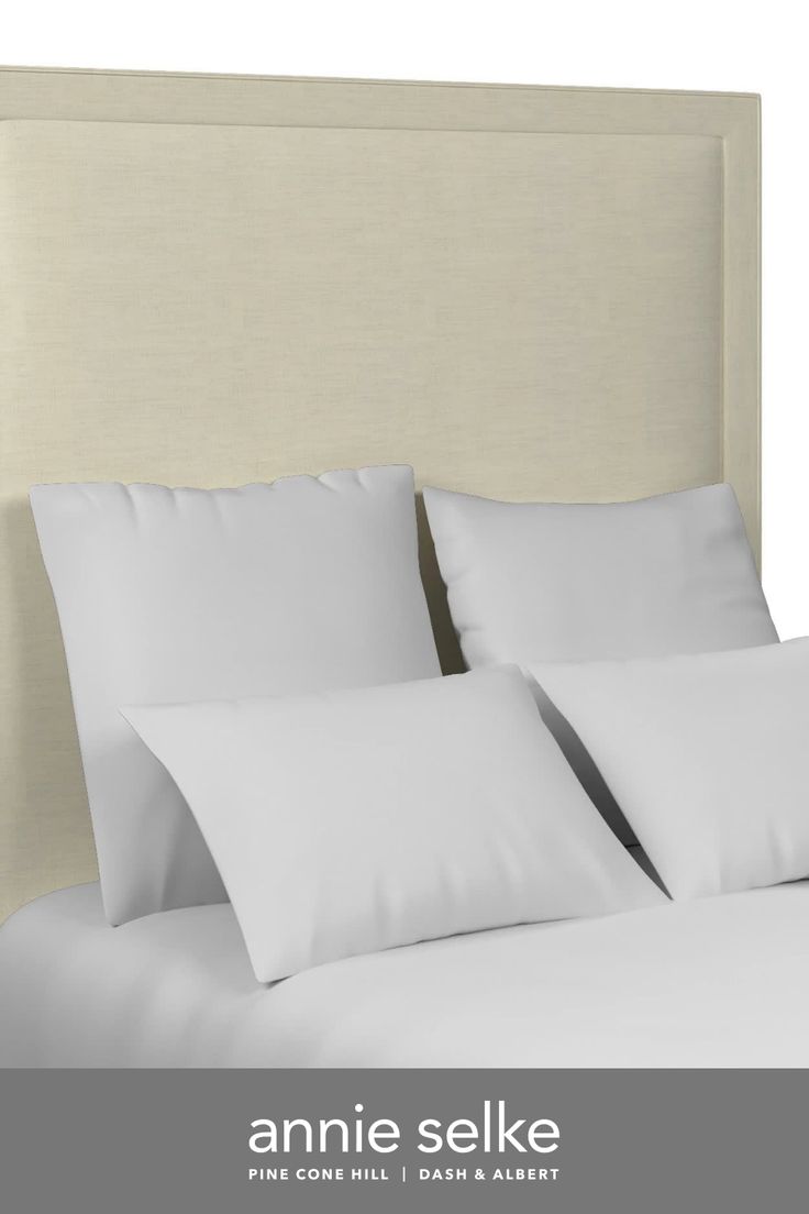 an image of a bed with white sheets and pillows on it's headboard