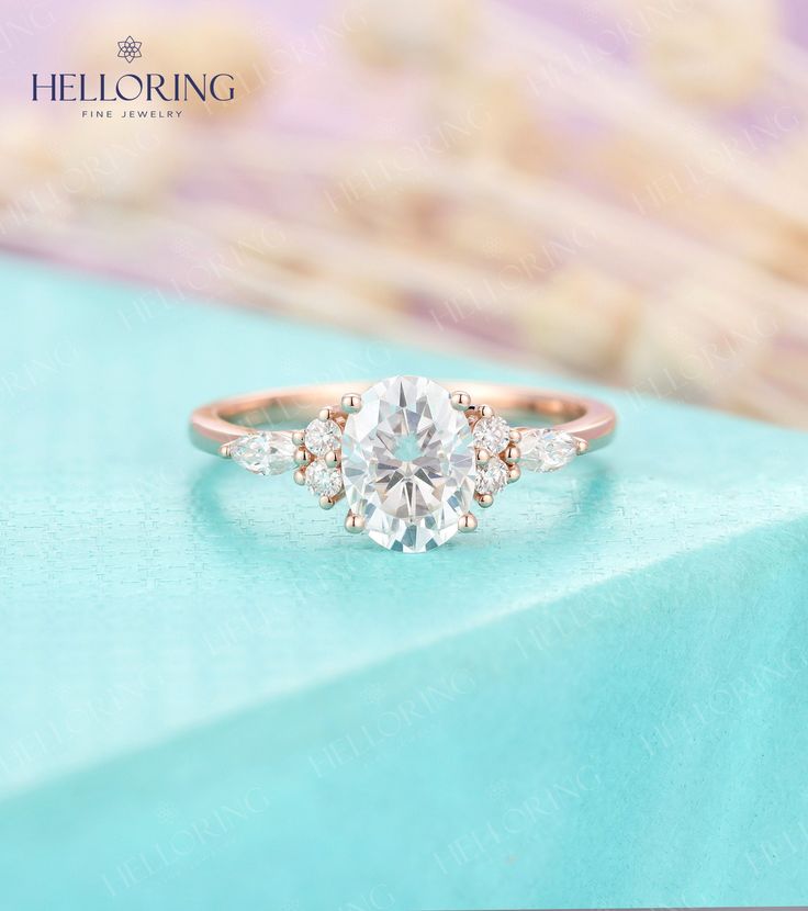 a close up view of a diamond ring on top of a blue table with the words hello