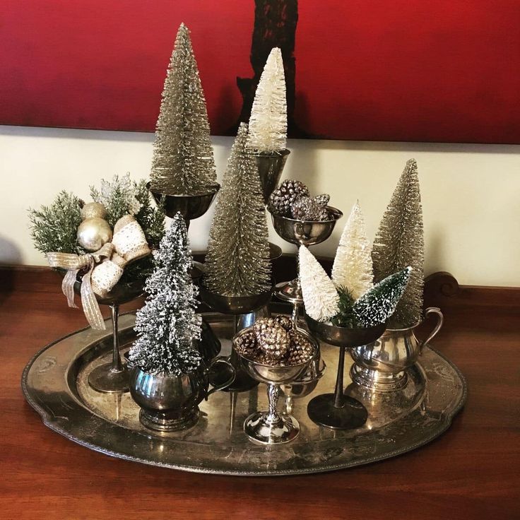 a tray topped with silver cups filled with christmas trees