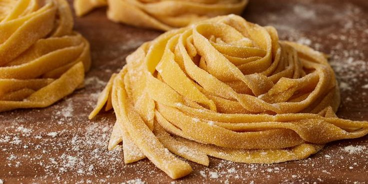 some kind of pasta that is on top of a wooden table with powdered sugar